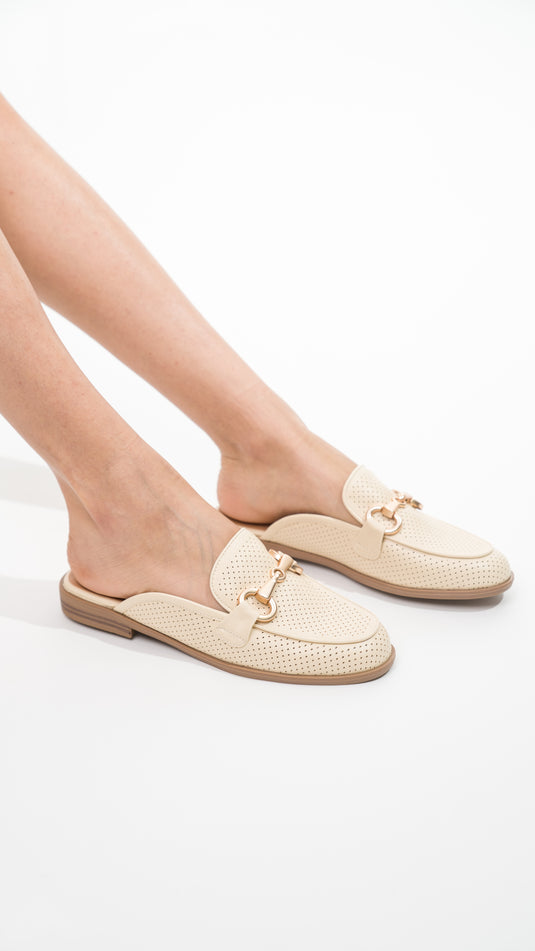 Off-white Manuella mules with decorative buckles, showcasing a stylish and comfortable design for casual wear.